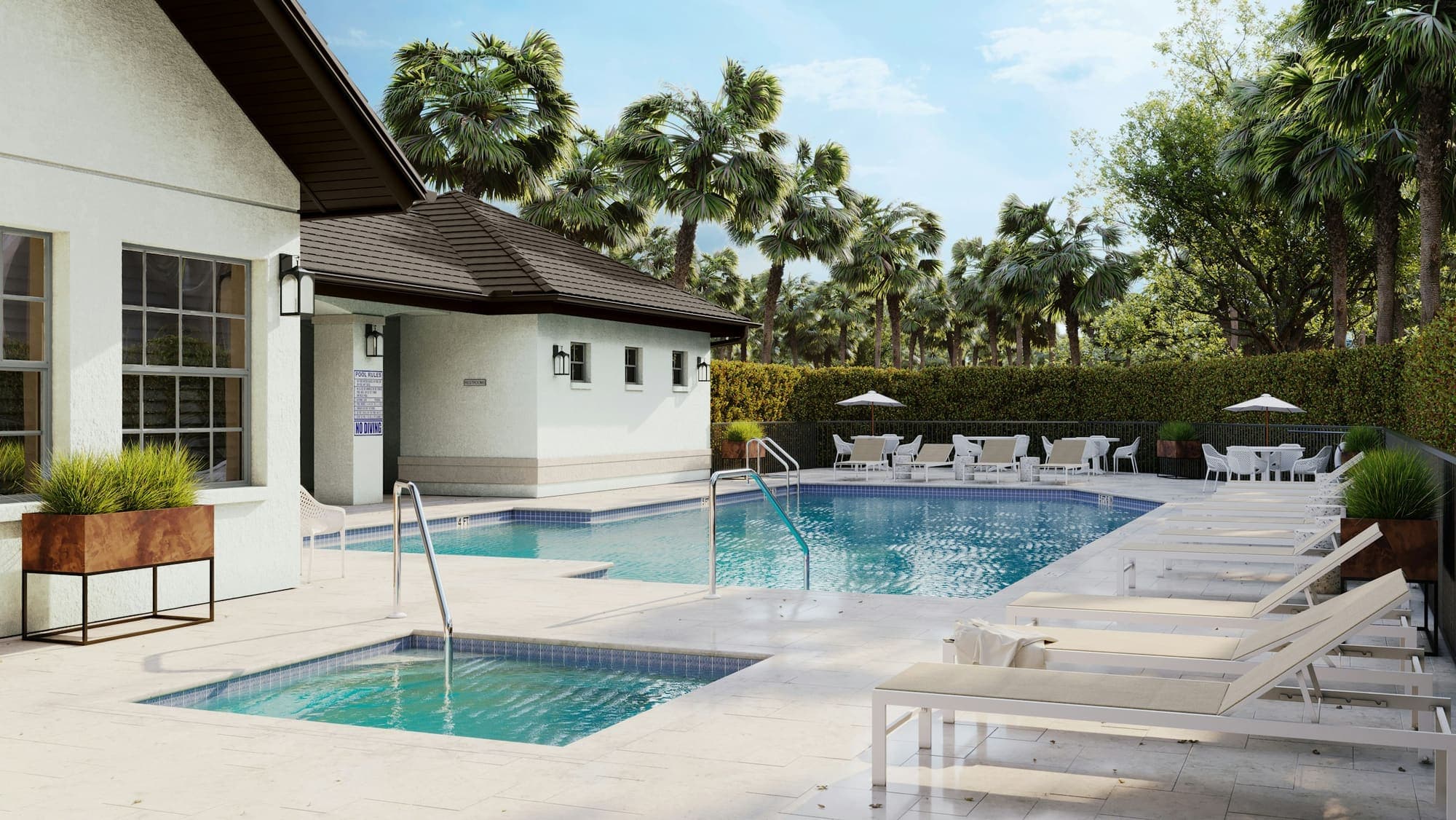 Pool and spa with lounge chairs, framed by palms and hedges